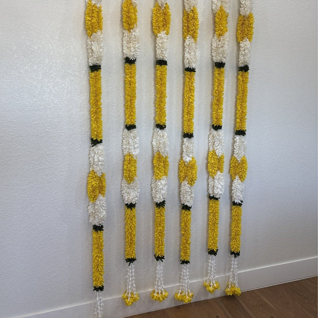 Set of 6 yellow and white marigold jasmine fabric garlands hung on wall – handmade Indian festive garland with green leaf accents and tassel ends