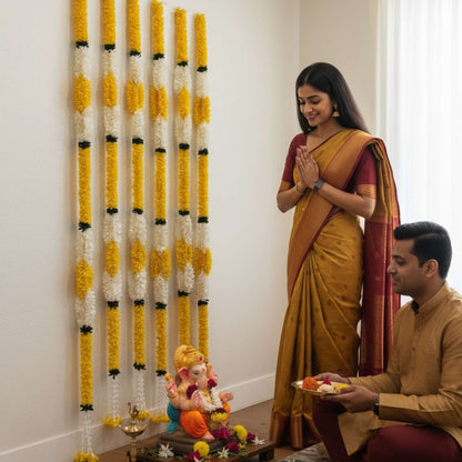 Couple doing Ganesh Chaturthi puja with fabric marigold jasmine garland decor backdrop