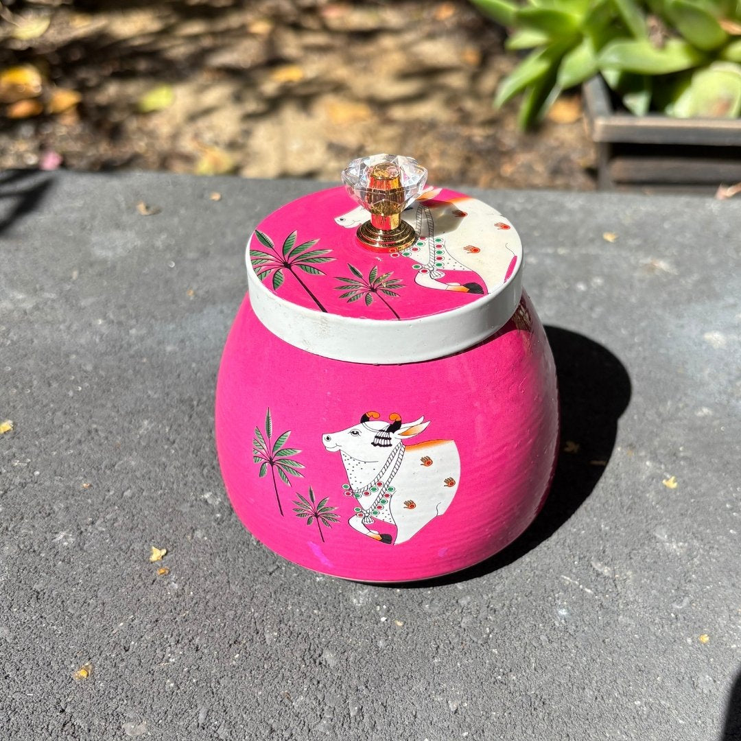 Pink container with a cow design on a gray surface