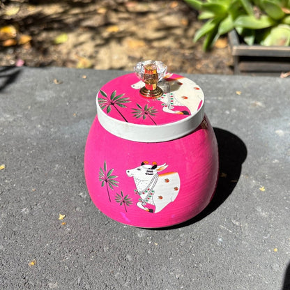 Pink container with a cow design on a gray surface