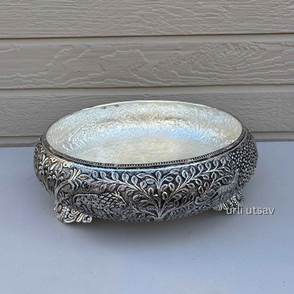 Jungle theme german silver urli bowl with intricate patterns on a white surface.