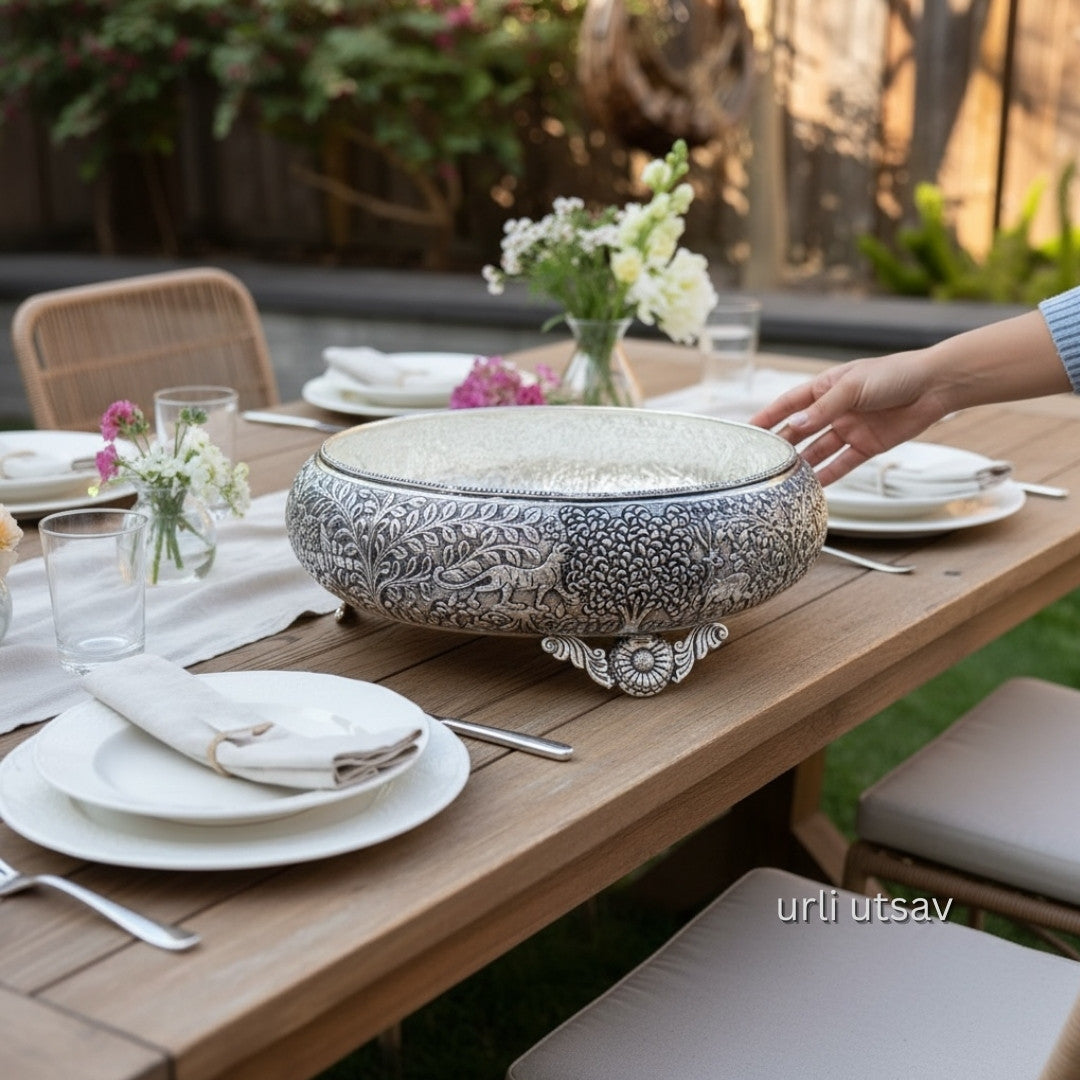 Jungle theme german silver urli bowl on a table with place settings and flowers