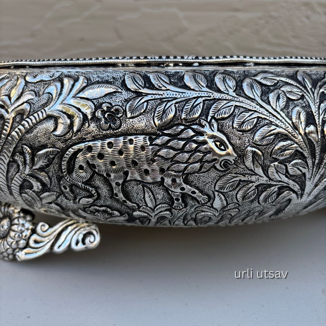 Close up of Jungle theme german silver urli bowl  with intricate designs and a panther emblem on a neutral background