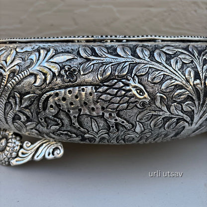 Close up of Jungle theme german silver urli bowl  with intricate designs and a panther emblem on a neutral background