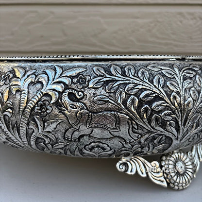 Close up of Jungle theme german silver urli bowl  with intricate floral patterns on a neutral background