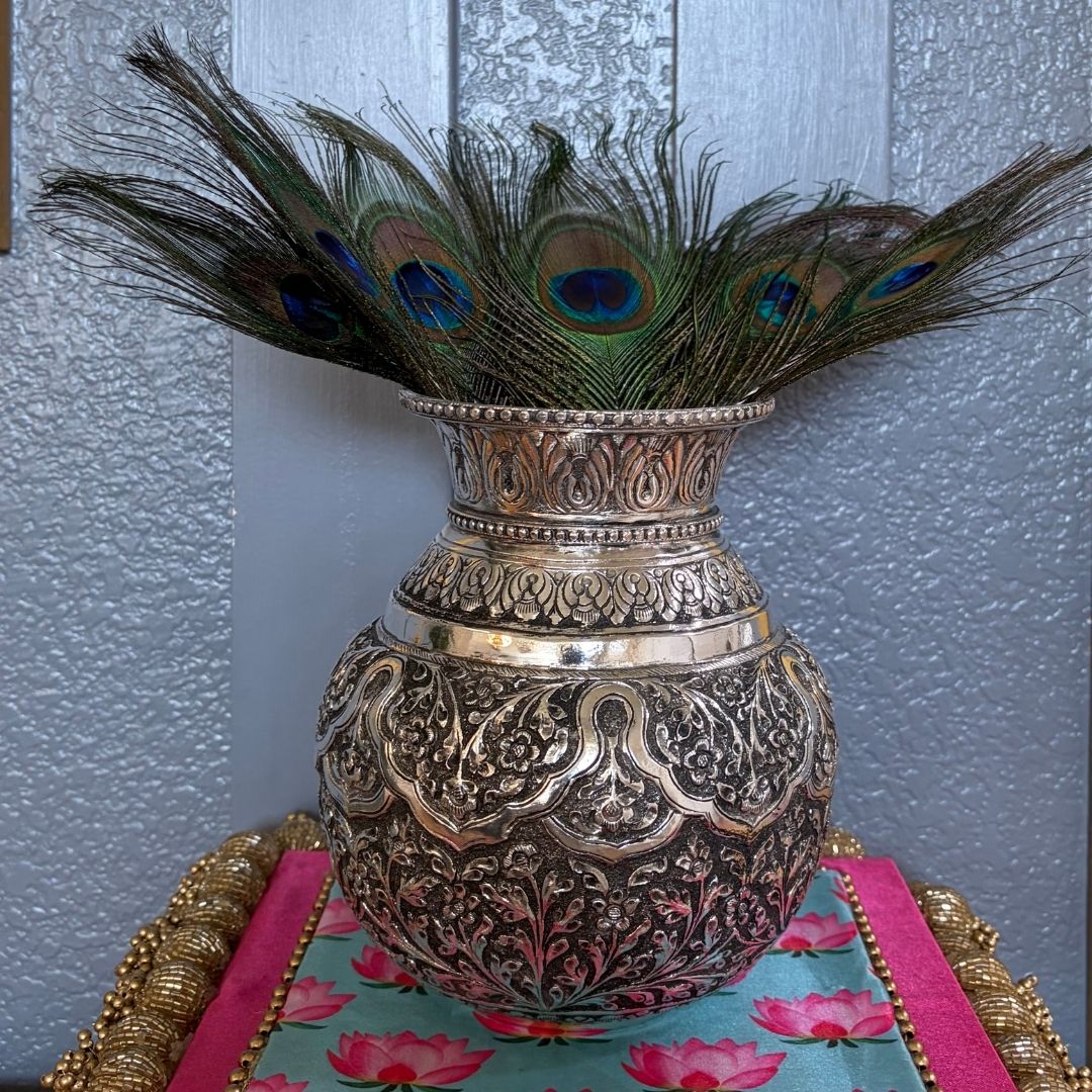 7-Inches Antique Silver Lota or Kalash with peacock feathers on a tablecloth with floral patterns.