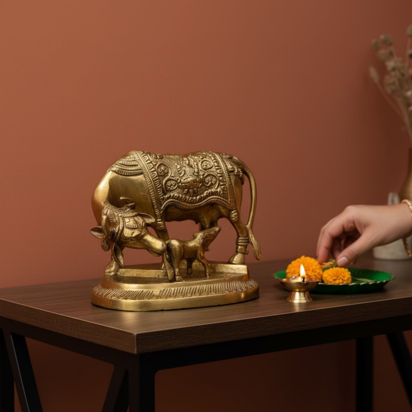 Brass Kamdhenu Cow and Calf idol styled with diya and marigolds for Diwali home decor