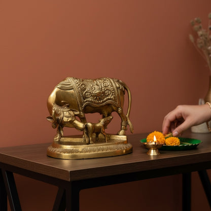 Brass Kamdhenu Cow and Calf idol styled with diya and marigolds for Diwali home decor