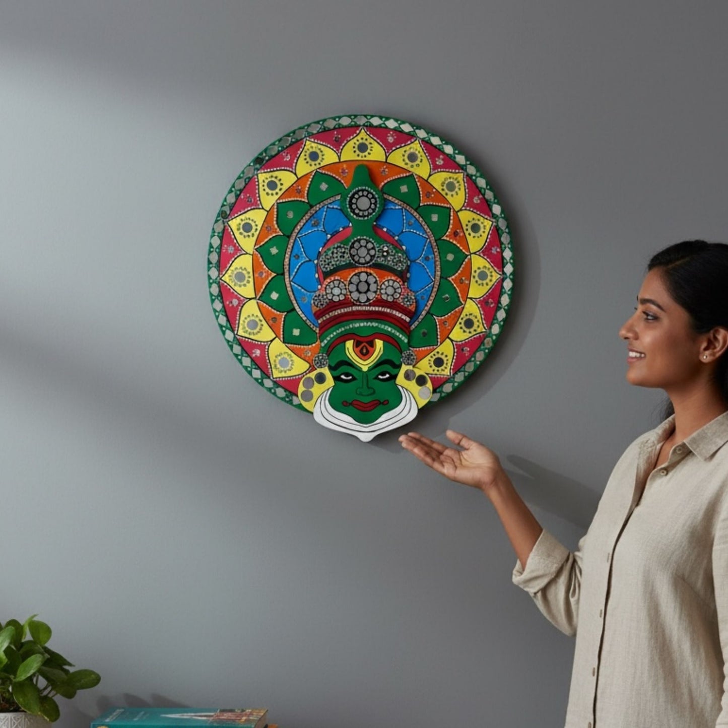 Woman admiring a 2ft round kathakali wall art piece on a gray wall
