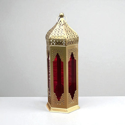 Detailed view of a Moroccan-style lantern with red stained glass panels and gold metal filigree, highlighting its handcrafted artistry.