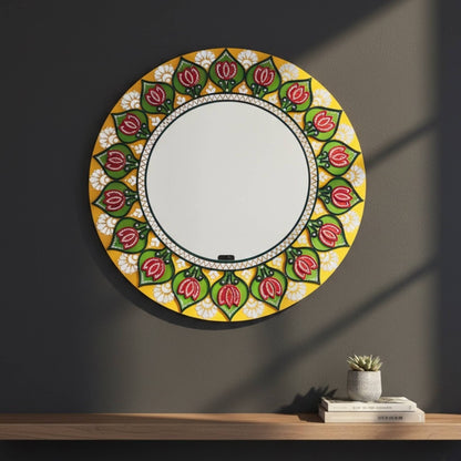 Decorative round mirror with floral pattern on a dark wall
