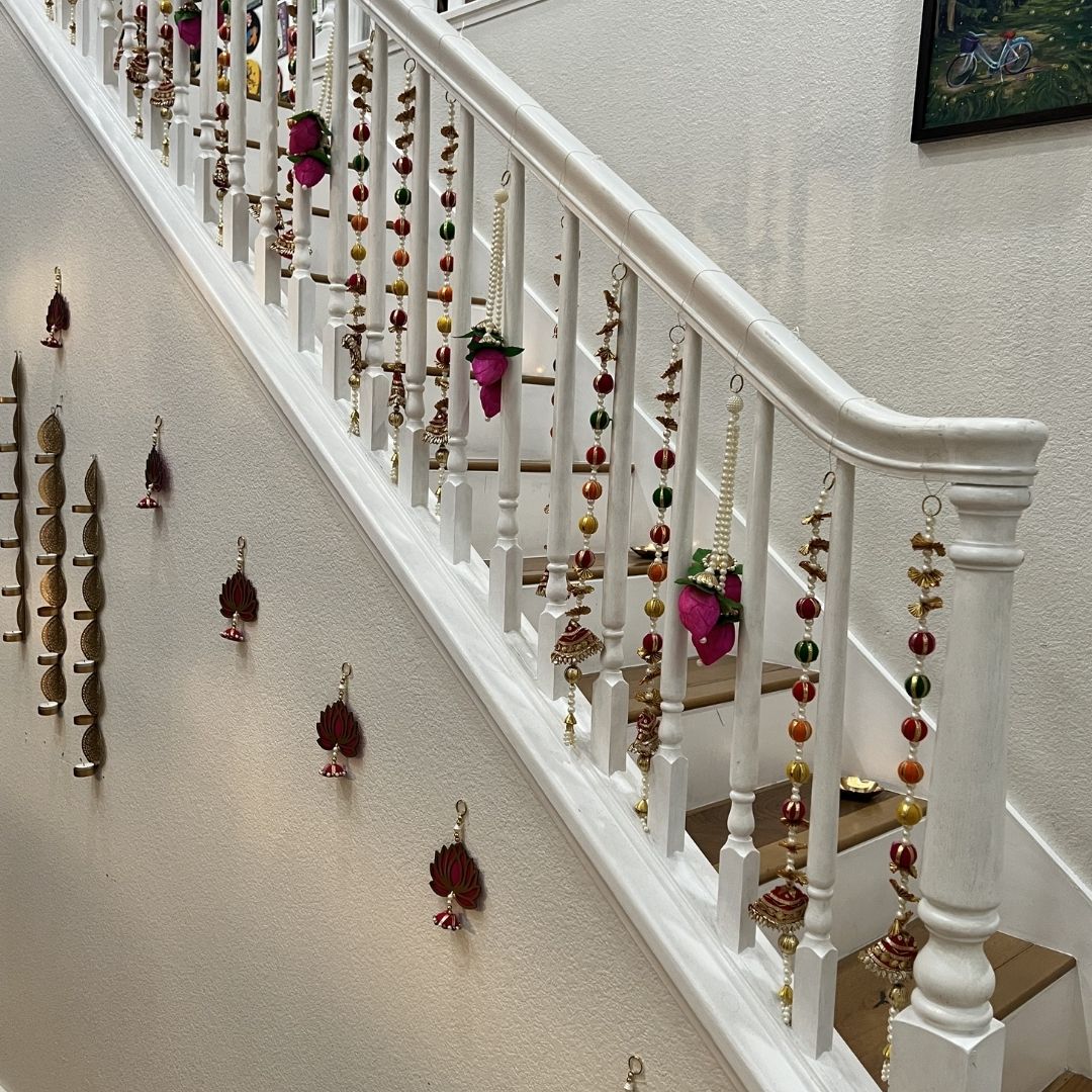 Set of handmade jasmine lotus bud fabric garlands hung on a staircase railing