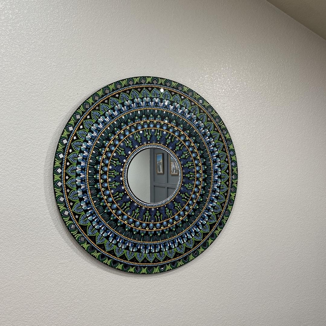 Hawaii Rainforest mandala mirror on a warm wall above a sideboard with dried grasses