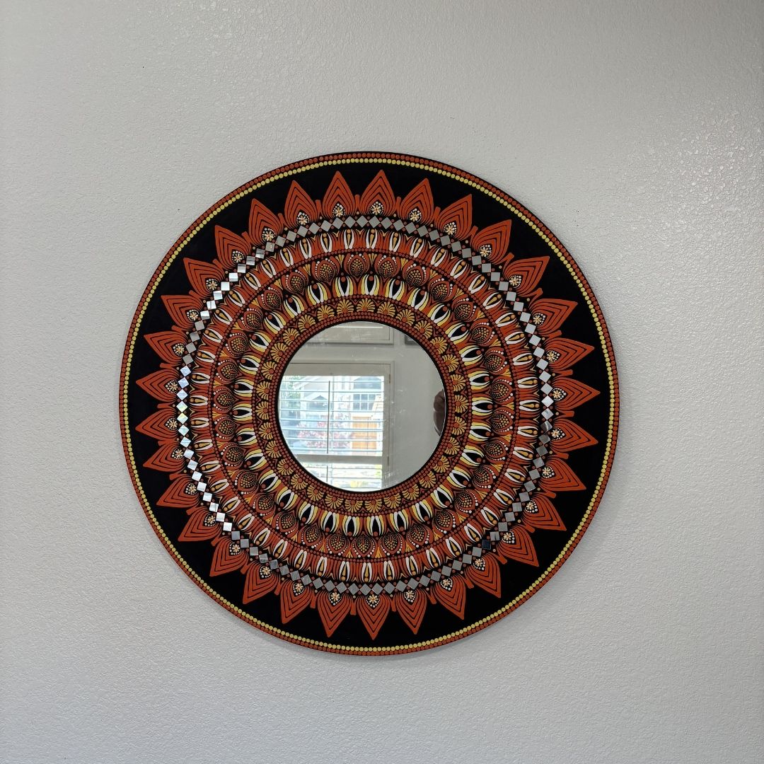 Black and gold mandala mirror design displayed on a plain wall