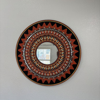 Black and gold mandala mirror design displayed on a plain wall