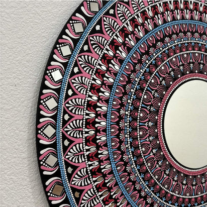 Pink, blue and black mandala mirror pattern close-up on textured white background 