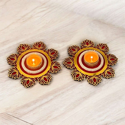 Two decorative candle holders with candles on a light wooden surface