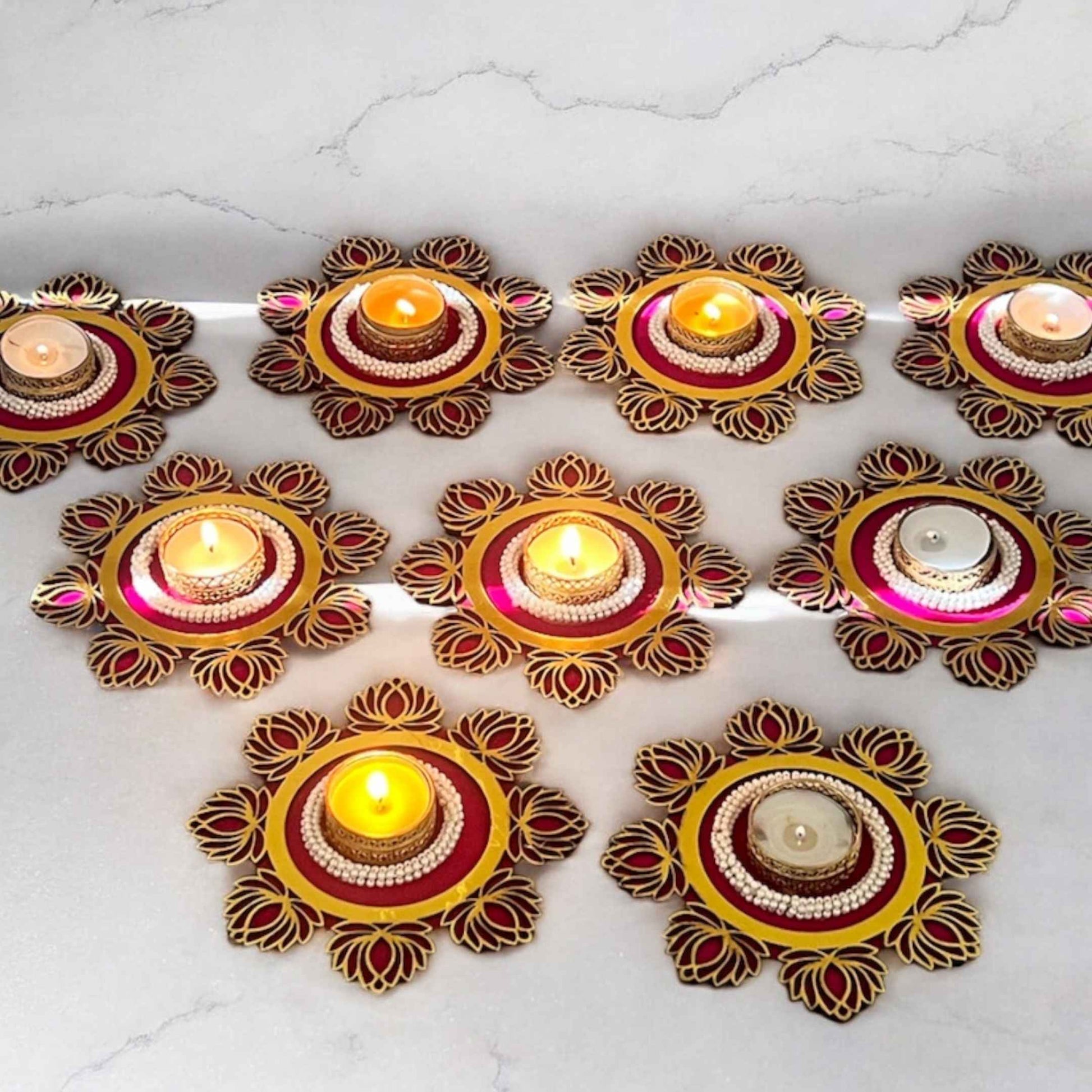 Decorative candle holders with candles on a white marble surface