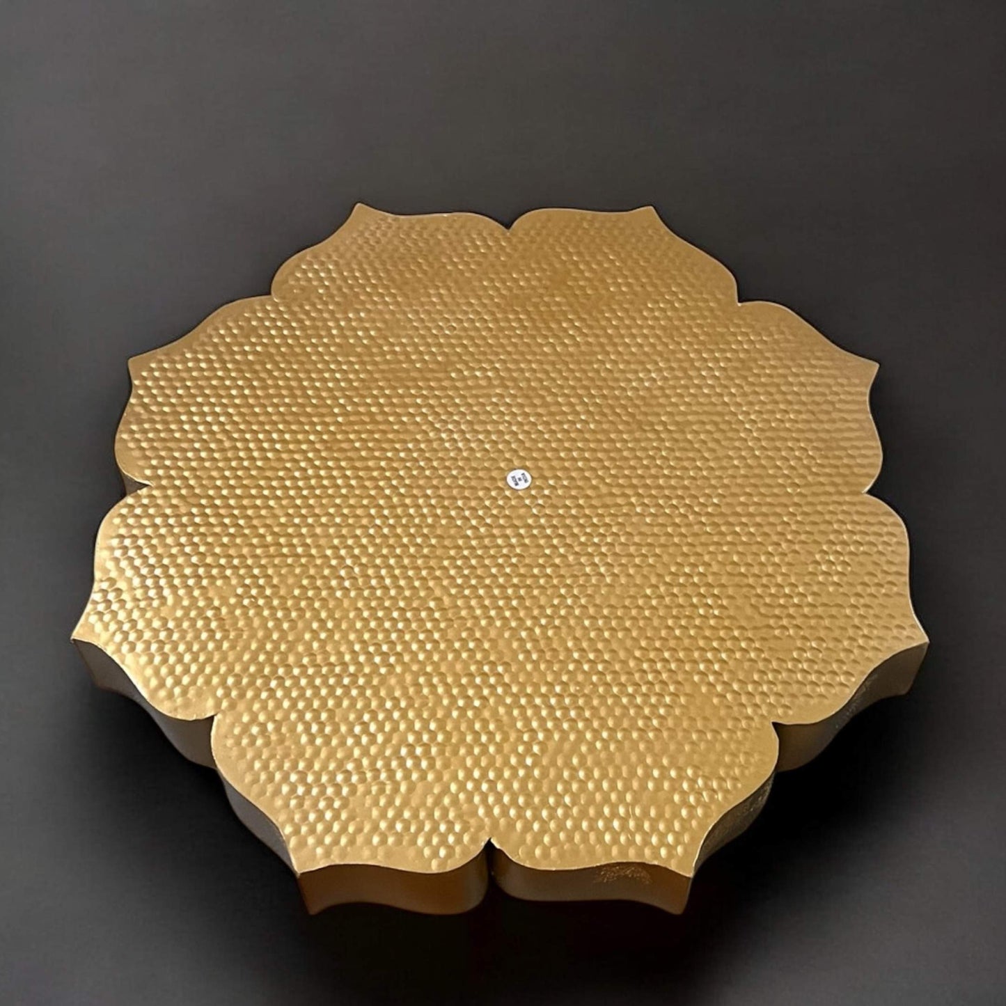 Gold textured circular urli backside on a dark background