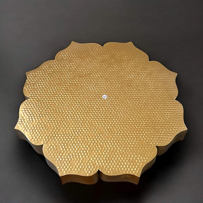 Gold textured circular urli backside on a dark background
