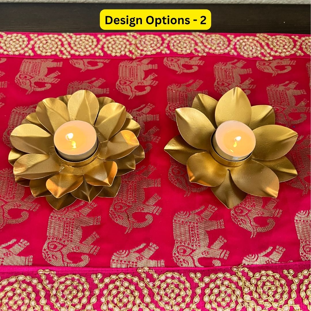 Two gold lotus t-light holders with lit tea lights on red and gold embroidered fabric, design option 2