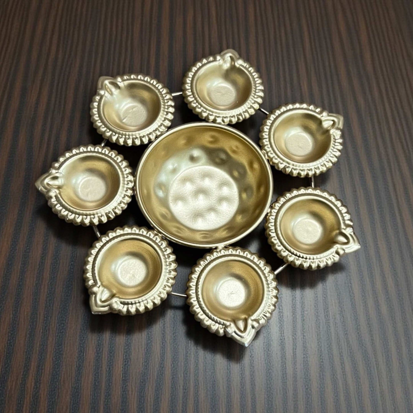 Detailed view of handcrafted hammered metal texture on a radiant gold polish Urli bowl