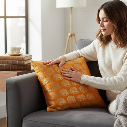 Woman arranging an orange pillow with elephant patterns on a gray sofa in a cozy living room.