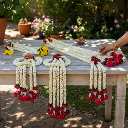 Decorative garlands on a table outdoors with a person's hand interacting with them.