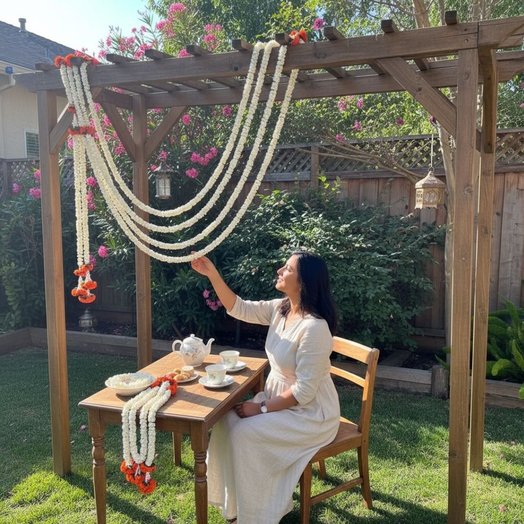 Woman in a garden setting with a decorated wooden pergola and table.