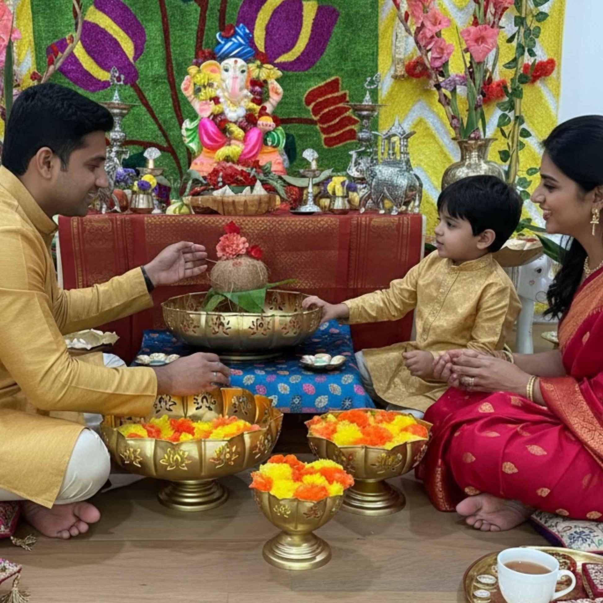 Lifestyle display featuring five gold lotus‑design urli bowls at varied heights, some filled with floating tea lights or flower petals, arranged on a wooden surface to visualize ganesh chaturthi decor use.