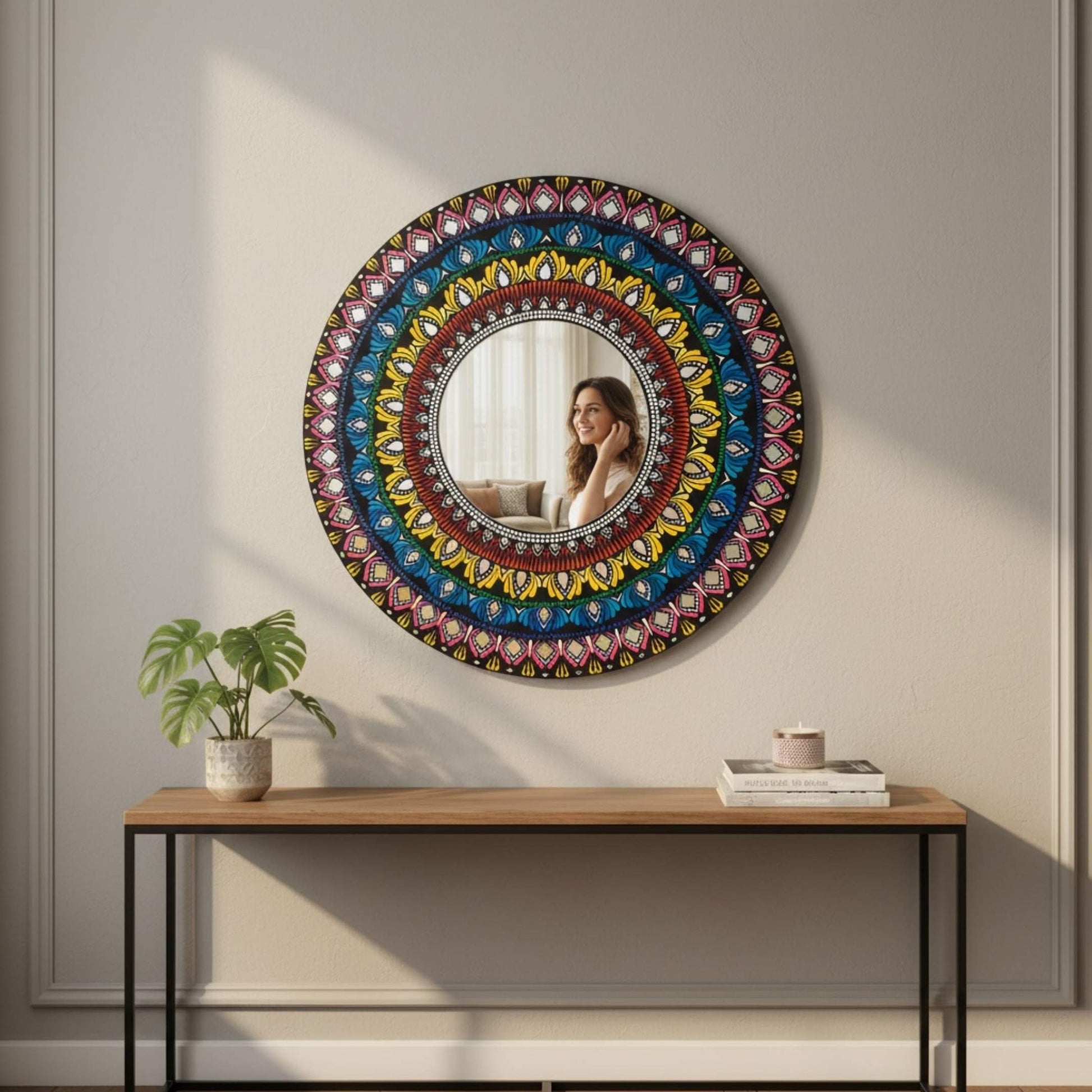 Decorative round mirror with colorful mandala pattern on a wall above a wooden console table.