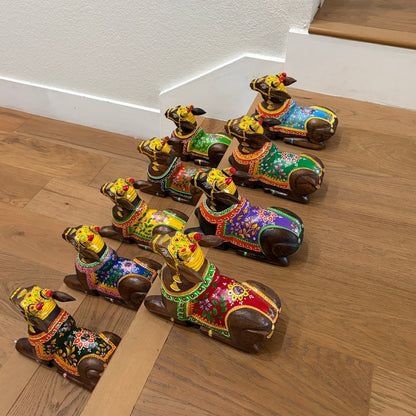 Colorful decorative dog figurines on a wooden floor