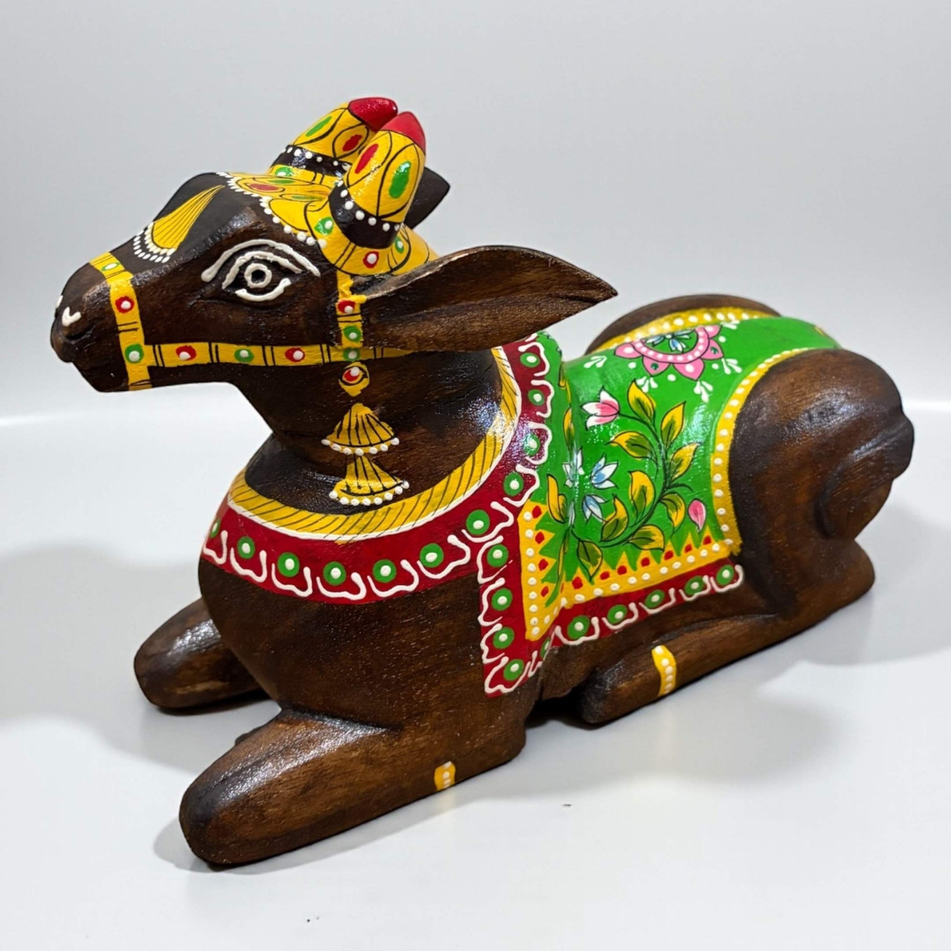 Decorative wooden bull figurine with colorful paint on a white background