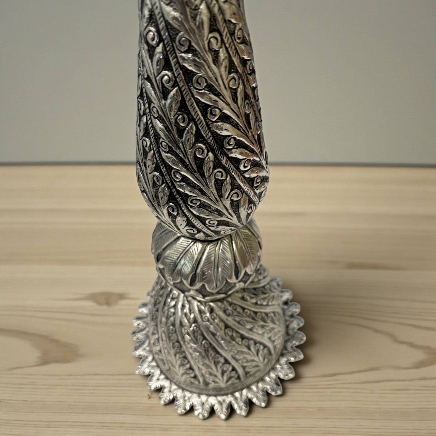 close-up of peacock engraving and antique silver finish on Nilavilakku traditional oil lamp