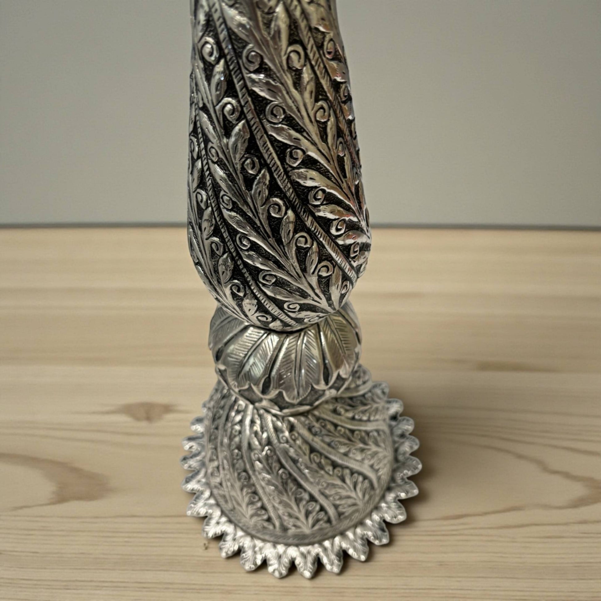 close-up of peacock engraving and antique silver finish on Nilavilakku traditional oil lamp