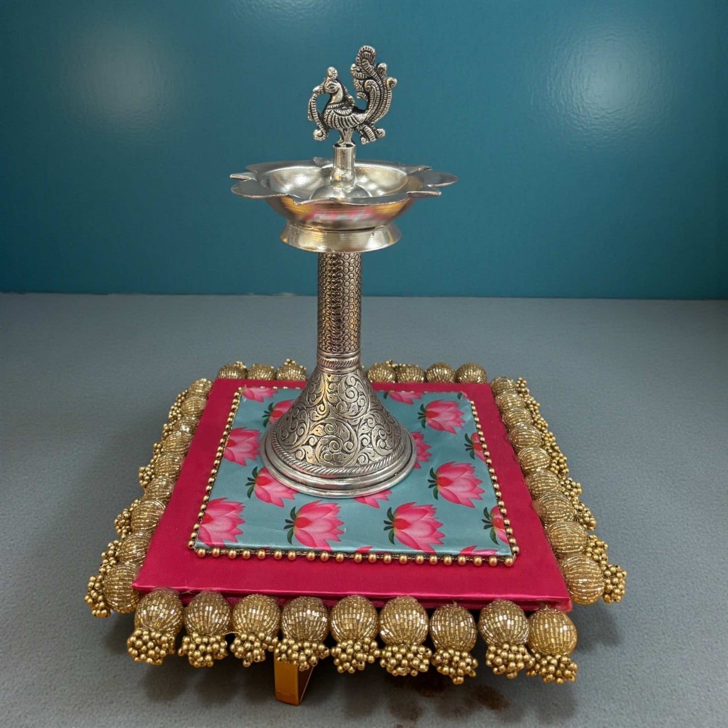 Decorative antique silver samai oil lamp with peacock motif on blue stand