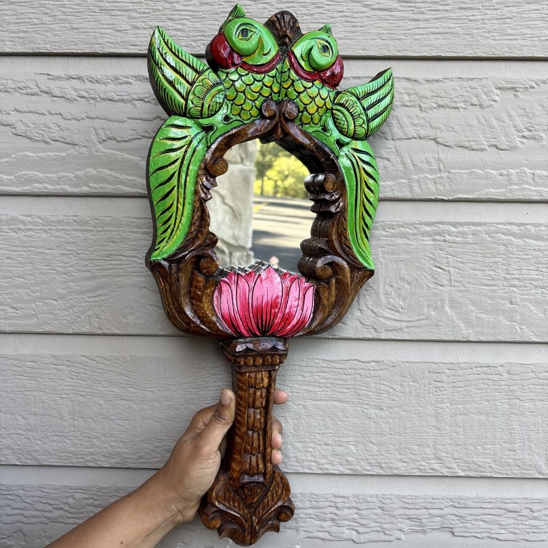 Hand holding vintage green parrot lotus carved wood mirror – handmade Indian artisan gift
