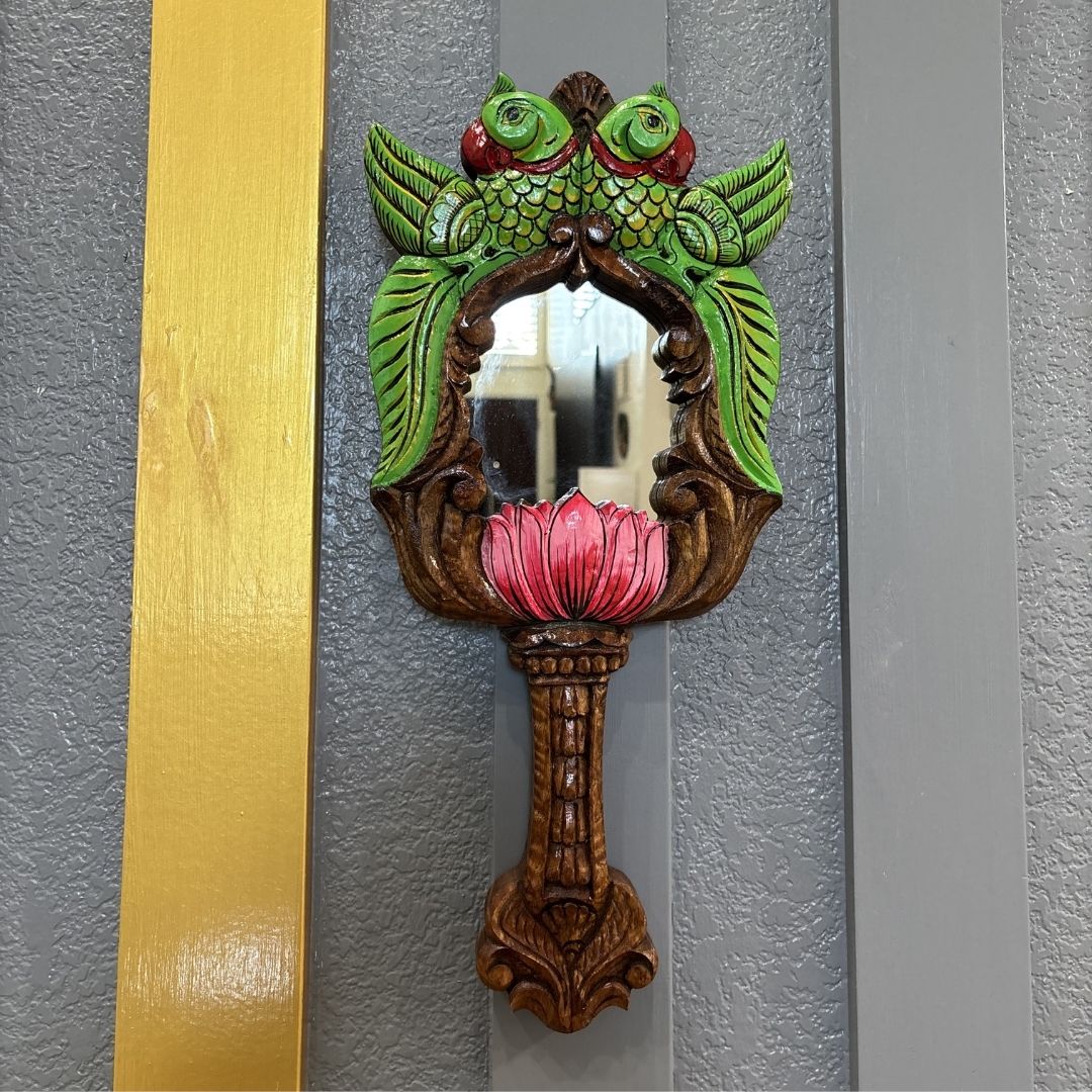 Hand-painted green parrot with red eyes and pink lotus – close-up of South Indian wood mirror