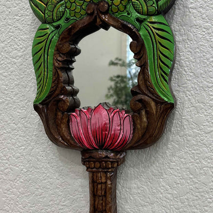 Pink lotus bloom and green leaf carving detail on hand-painted Indian wooden wall mirror