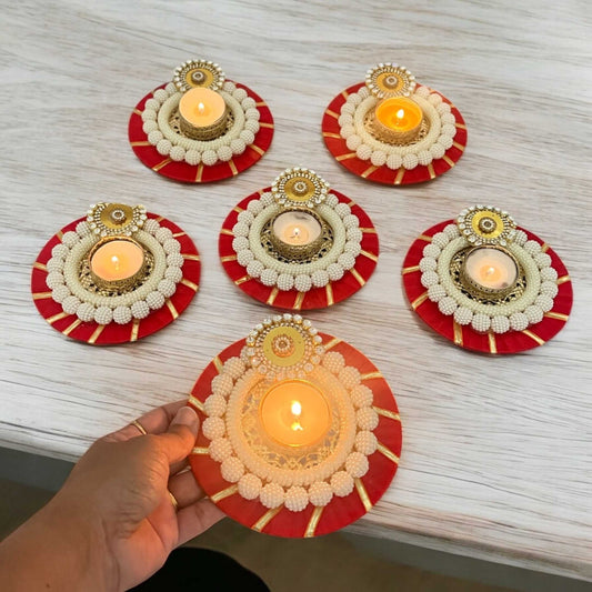 Decorative candle holders with candles on a light wooden surface