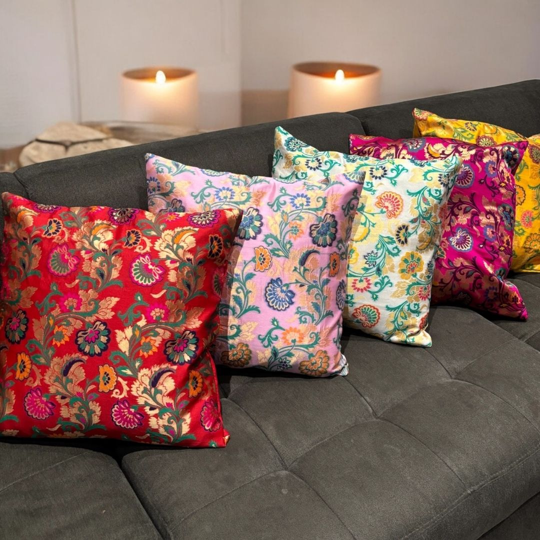 Set of 5 vibrant silk blend Banarasi brocade floral cushion covers arranged on a sofa