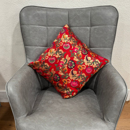 Close-up of a red 16x16 inch silk blend Banarasi brocade cushion cover with golden floral motifs