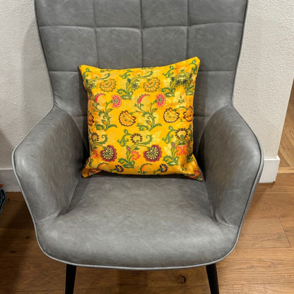 Close-up of a yellow 16x16 inch silk blend Banarasi brocade cushion cover with golden floral motifs