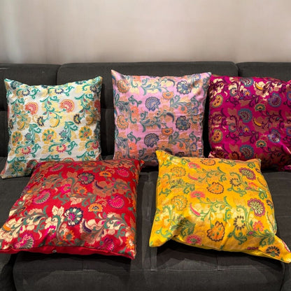 Vibrant silk brocade floral cushion covers decorating a sofa in a modern boho living room