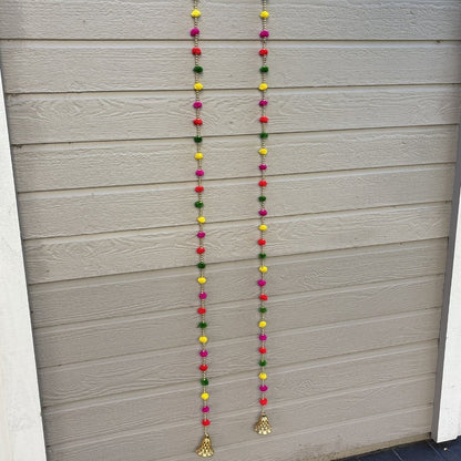 Close-up of woolen pompom garland with golden beads and bell, 5 ft string
