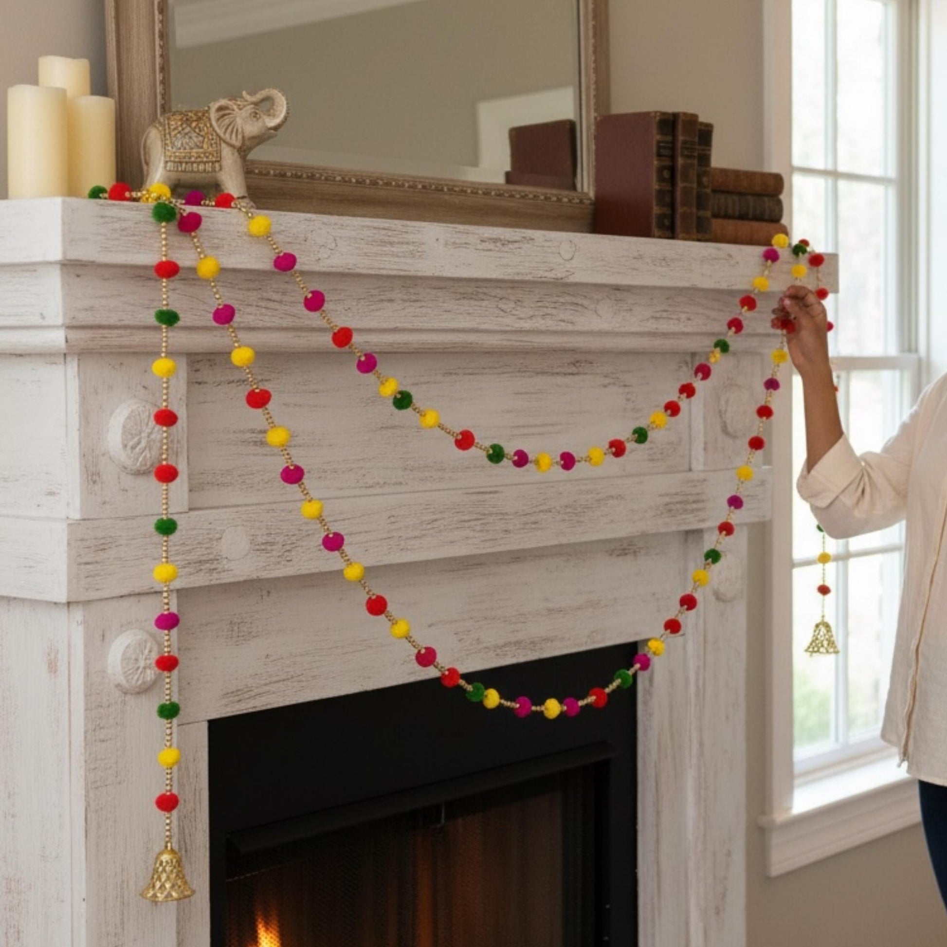 Colorful pompom garland hung on fireplace mantel for festive home decoration