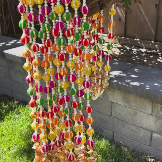 video of Set of 10 multicolor woolen pom pom garlands with pearl and gota embellishments, displayed vertically against a neutral background