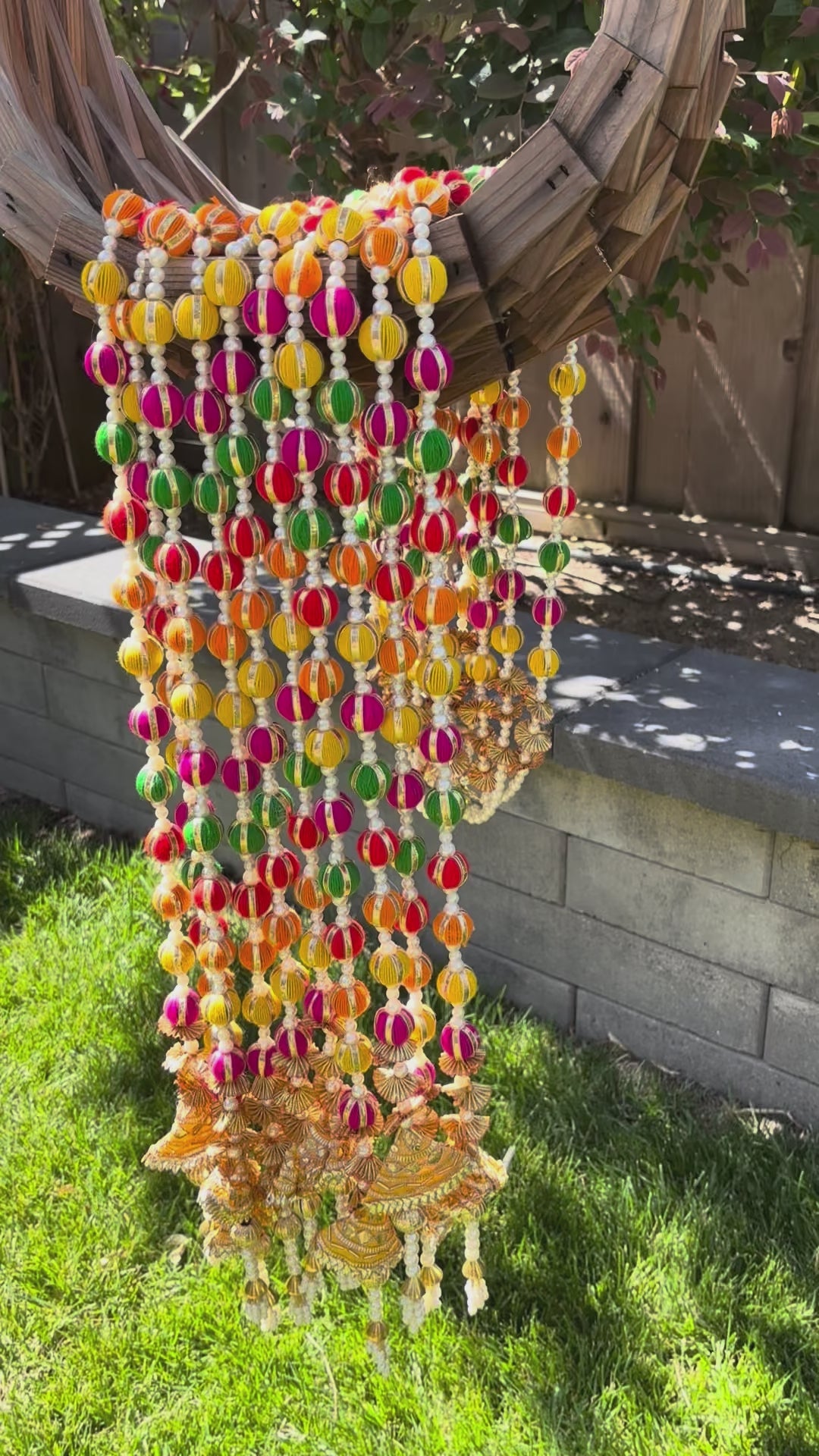 video of Set of 10 multicolor woolen pom pom garlands with pearl and gota embellishments, displayed vertically against a neutral background