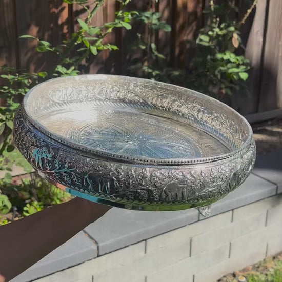 Video of the 13.5-inch antique silver elephant urli bowl: close-up of the raised elephant work, water poured in, then filled with red rose petals and floating tealights