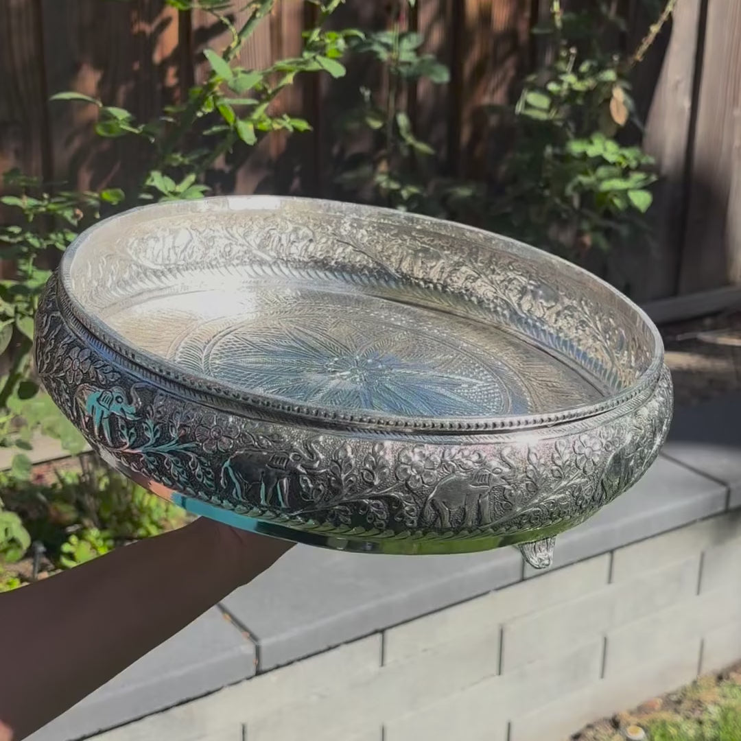 Video of the 13.5-inch antique silver elephant urli bowl: close-up of the raised elephant work, water poured in, then filled with red rose petals and floating tealights